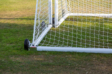 The bottom of some moveable football goal posts and nets