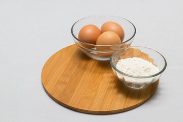 eggs and flour on white table background. basic baking background.