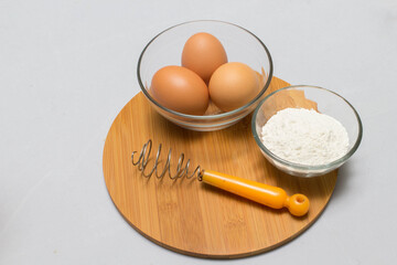 eggs and flour on white table background. basic baking background.