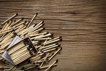 a pile of matches with a box on a wooden background