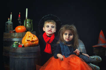 Funny children in costumes on Halloween eve in the Studio on a dark background .