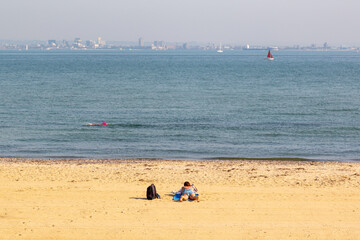 A woman sunbathing alone on a golden sandy beach