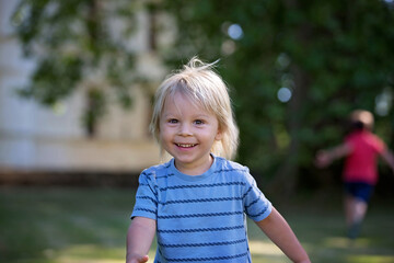 Child, toddler boy, playing in the park, running happily