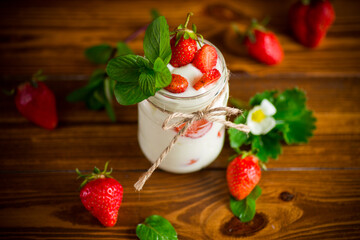 sweet homemade yogurt with ripe fresh strawberries in a jar