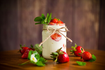 sweet homemade yogurt with ripe fresh strawberries in a jar