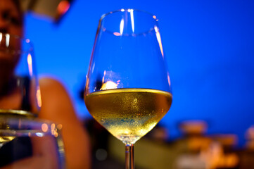 Glass of cold dry white wine served outdoor in cafe at night in Italy