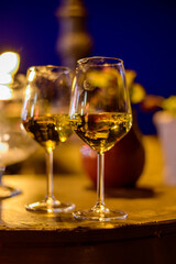 Two glasses of cold dry white wine served outdoor in cafe at night in Italy