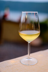 Glass of cold dry white wine served outdoor in cafe at night in Italy