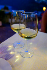 Two glasses of cold dry white wine served outdoor in cafe at night in Italy