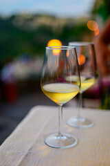 Two glasses of cold dry white wine served outdoor in cafe at night in Italy
