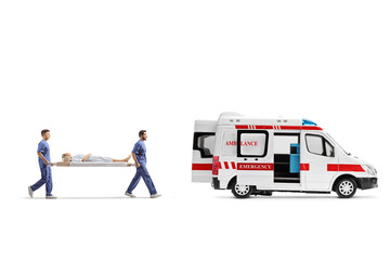 Healthcare workers carrying a stretcher with a patient into an ambulance vehicle