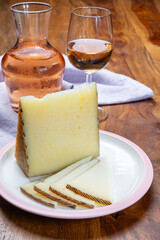 Cheese collection, pieces of sheep hard manchego cheese made in La Mancha, Spain and cold rose wine in glass