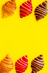 Frame of croissants - fresh bakery on yellow background. Top view