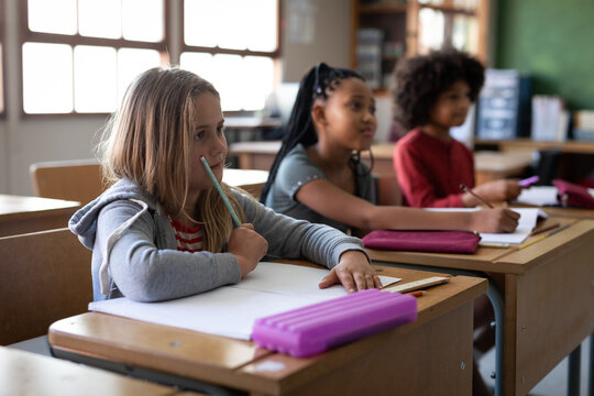 Group of kids sitting on their desk in the class at school