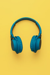 Blue headphone on yellow background. Music concept.