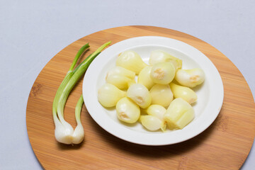 three pickled onions with parsley on white background
