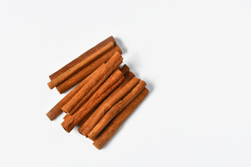 A top view image of several fresh cinnamon sticks on a white background.