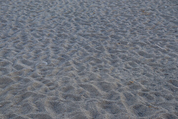 Pebble beach by the sea. Sand with footprints of people. Italian beach, Calabria.