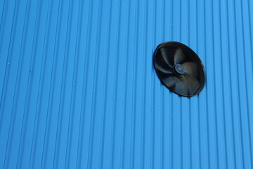 fan on the wall of the blue hangar