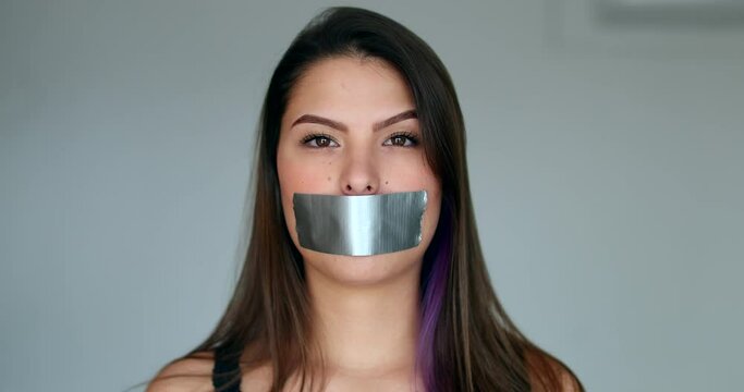 Woman mouth taped looking at camera