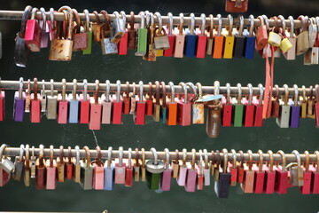 Viele bunte Liebeschlösser hängen an einer Brücke