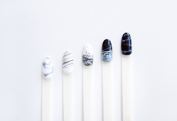 nail samples with black and white manicure design laid out in a line