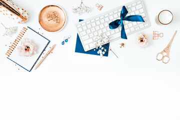 Workplace flat lay with keyboard and various items in gold and blue colors, copy space, horizontal, blog image