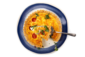 top down view of a cheese quiche pie with dried tomatoes with one piece cut out ready to serve isolated on white