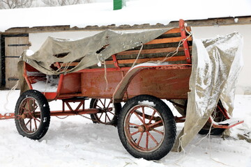 Fototapeta na wymiar old style cart under snowfall