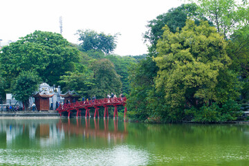 The Huc Bridge or Sun shine bridge at Hoan Kiem Lake, It`s a red wooden arch bridge.
