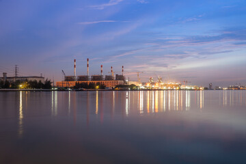 power plant reflection on river againts sky