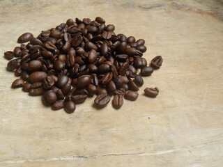 Granos de  café tostado sobre mesa rústica de madera