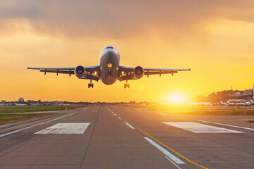 Fototapeta na wymiar Commercial airliner on runway at dusk bright sunset time.