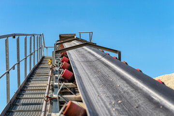 Close-up shot of the conveyor belt in the concrete plant with transport rollers, visible metal...