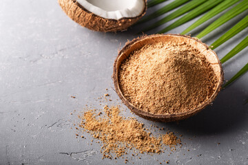 Organic brown palm sugar on grey concrete background with copyspace.