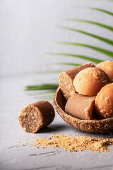 Different shape of organic brown palm sugar on grey concrete background.