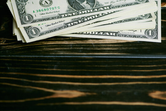 stack of one dollar bills on a wooden background with copy space