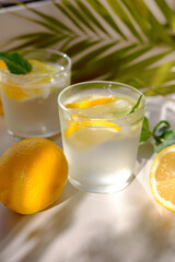 Lemon water with fresh lemons and green plants. Water balance in the body