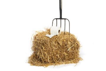 farm barn comfort, a roll of toilet paper on a pitch fork on a straw bale isolated on white