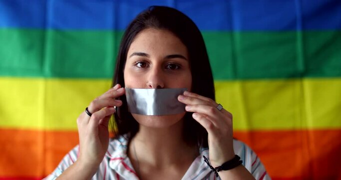 Woman with mouth tape in mouth unable to speak. Censored LGBT girl