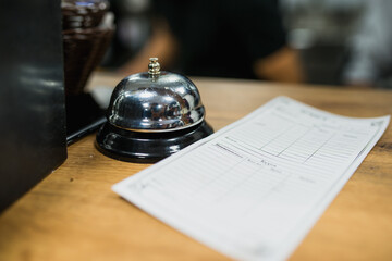 an empty receipt is on the bar next to the chef's bell