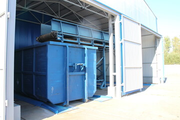 Blue waste containers in a large hangar