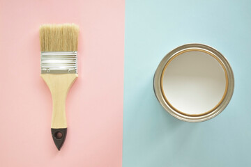 One open can of white paint with a brush, on a bright background. The view from the top. The concept of renovation.