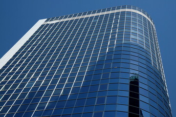 Obraz na płótnie Canvas Geschwungene blaue Glasfassade eines modernen Bürogebäude im Sonnenschein an der Neuen Mainzer Straße in der Innenstadt von Frankfurt am Main in Hessen