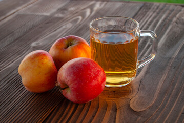 a glass of an apple juice on a wooden table