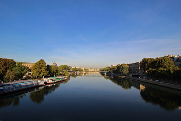 Fototapeta na wymiar Seine river with tour boat at sunny summer sunrise, Paris, France.