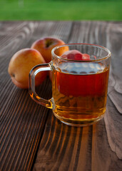 a glass of an apple juice on a wooden table