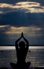 silhouette of a person doing yoga at the beach