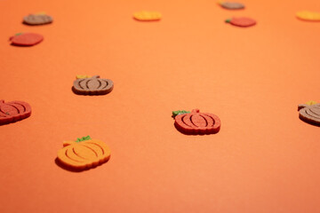 Felt pumpkins on orange desk close up with copy space