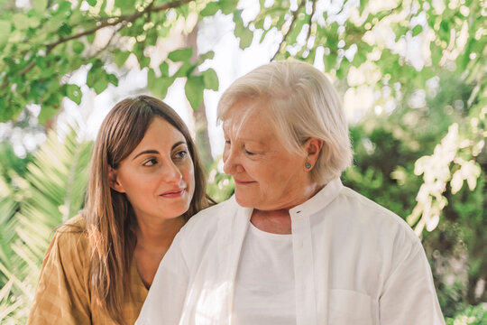 Close-up of smiling mother and daughter looking at each other in yard